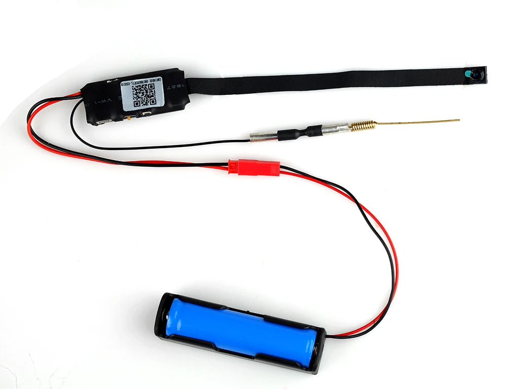 Spy Tech Flexible Hidden Camera with a QR code display, black strap, wiring, and blue cylindrical battery. Attached to the wiring is a small cylindrical metal component with red and black wires connecting the parts. Features motion detection and a mini camera providing 1080P Full-HD video.